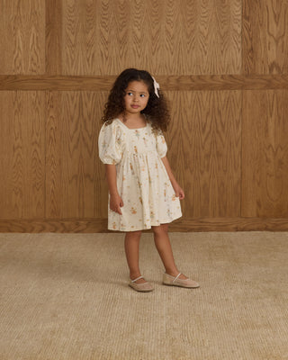 Rylee & Cru Brea Dress - Nutcracker
Young girl in a floral dress standing against a wooden paneled wall.
