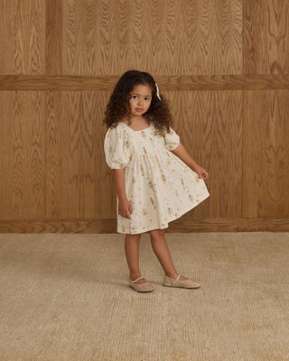 Rylee & Cru Brea Dress - Nutcracker
Young girl in a floral dress standing against a wooden paneled wall.