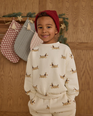 Rylee & Cru Relaxed Sweatshirt & Jogger Sweatpant Set - Christmas Dogs
Child wearing a cream sweatshirt with dog pattern in front of wooden wall with stockings.