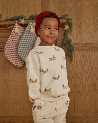 Rylee & Cru Relaxed Sweatshirt & Jogger Sweatpant Set - Christmas Dogs
Child wearing a white sweater with dog prints in front of a wooden wall with stockings.