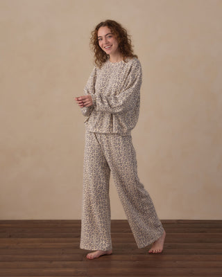 Rylee & Cru Women's Oversized Sweatshirt - Blue Leopard
A woman stands barefoot on a wooden floor against a beige wall, wearing a matching two-piece lounge set with a beige and brown abstract print. The set includes a long-sleeve top and wide-leg pants.