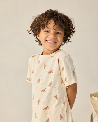 Rylee & Cru Play Set - Lobster
Child wearing a cream-colored shirt with small patterns on a plain background