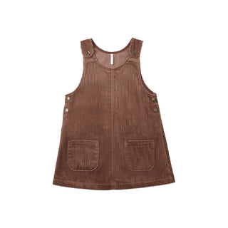 Rylee & Cru Odette Overall Dress - Mulberry
A brown corduroy pinafore dress for toddlers, featuring front patch pockets and decorative buttons on the shoulder straps and armholes, shown against a plain white background.