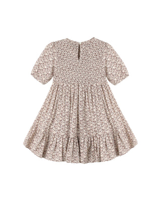 Rylee & Cru India Dress - Primrose
A short-sleeve baby dress with a dense beige and brown floral pattern, featuring a smocked bodice and a ruffled hem, shown flat against a white background.