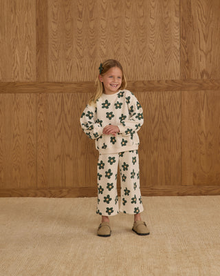 Rylee & Cru Oversized Sweatshirt & Wide Leg Sweatpant Set - Daisy
Young girl wearing a floral outfit standing against a wooden paneled wall.