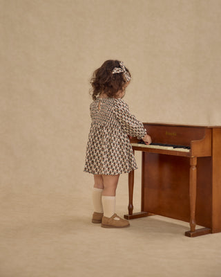 Rylee & Cru Capri Dress - Harvest Floral
Child playing a piano against a beige background