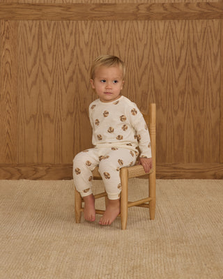 Rylee & Cru Long Sleeve Tee + Pant Set - Basketball
Child wearing a patterned outfit sitting on a wooden chair against a wooden paneled wall.
