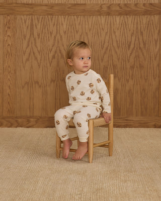 Rylee & Cru Long Sleeve Tee + Pant Set - Basketball
Child wearing a white outfit with brown patterns sitting on a wooden chair against a wooden paneled wall.