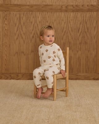 Rylee & Cru Long Sleeve Tee + Pant Set - Basketball
Child sitting on a wooden chair wearing a white long-sleeve shirt and pants with brown patterns against a wooden paneled wall.