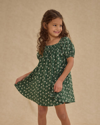 Rylee & Cru Sabrina Mini Dress - Green Ditsy
Young girl wearing a green floral dress against a beige background