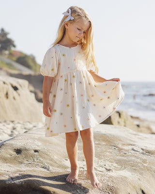 Rylee & Cru Marley dress with embroidered daisies, lightweight cotton fabric, and ruffle details on a child wearing the dress.