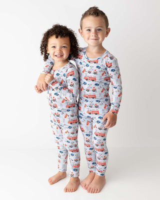 Lev Baby Poppy Convertible Zipper Romper - Ryan
Two children wearing pajamas with fire truck pattern on a white background