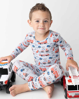 Lev Baby Pajama Set - Ryan
Child wearing pajamas with vehicle pattern, sitting with toy cars on a white background