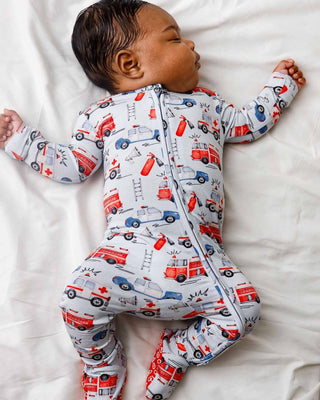Lev Baby Zippered Footie - Ryan
Baby wearing a onesie with vehicle pattern on a white blanket
