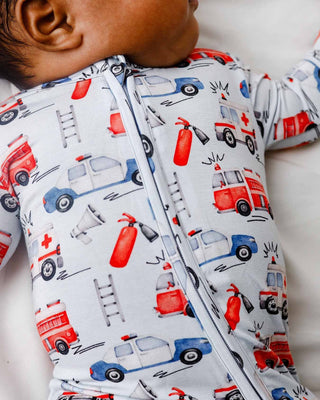 Lev Baby Zippered Footie - Ryan
Baby wearing a onesie with emergency vehicle pattern on a light background