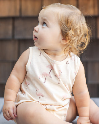 Rylee & Cru Bubble Romper - Flamingo
Baby wearing a light-colored sleeveless outfit with a subtle pattern, sitting against a wooden background.