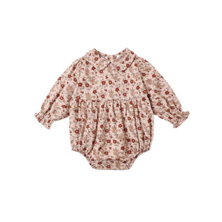 Rylee & Cru Cora Romper - Pink Floral
A baby long-sleeve romper in a beige and brown floral print with red accents, featuring a Peter Pan collar, smocked chest, and elastic leg cuffs, shown flat on a white background.