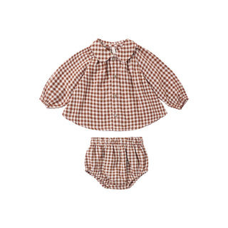 Rylee & Cru Nellie Set - Brick Check
A two-piece baby outfit set featuring a long-sleeve button-up shirt and matching bloomers in a brown and white gingham check pattern, displayed flat on a white background.