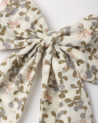 Rylee & Cru Oversized Bow - Winter Garden
 A close-up of a fabric hair bow with a delicate botanical print featuring olive green leaves, muted gray-blue berries, and soft pink blossoms on a warm cream background.
