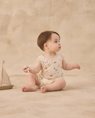 Rylee & Cru Sleeveless One-Piece - Aquatic
Baby in a floral onesie sitting on a beige surface with a wooden toy boat.