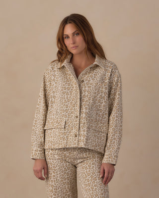 Rylee & Cru Women's Claire Jacket - Leopard
A woman modeling a matching two-piece pajama set with a beige and brown leopard print pattern, featuring a long-sleeve button-up shirt and coordinating pants, set against a solid beige studio background.