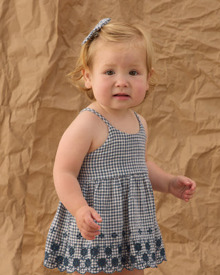 Rylee & Cru Zenni Set - Marine Gingham Young child wearing a checkered dress against a brown backdrop