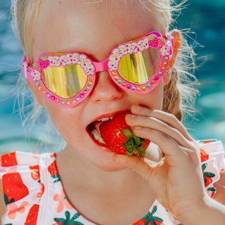 Bling2o Strawberry Shortcake Heart Shaped Swim Goggles
Child wearing colorful sunglasses and eating a strawberry by a pool