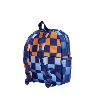 State Bags Kane Backpack - Gradient Checkerboard
A backpack with a blue, navy, and orange checkerboard pattern, shown from a three-quarters angle on a solid white background.
