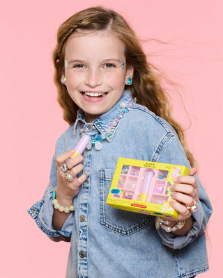 Super Smalls Mermaid Magic Lip Balm Bead Kit
Girl holding a toy makeup set and brush against a pink background