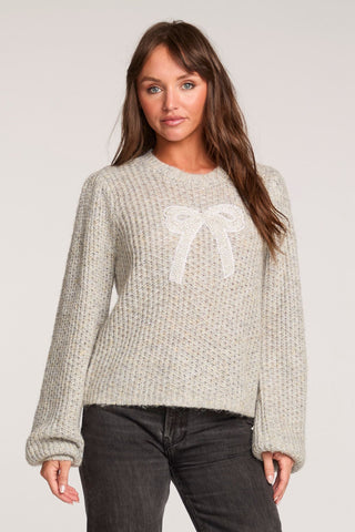 Saltwater Luxe Long Sleeve Bow Sweater in Heather Grey
Woman wearing a light gray sweater with a white bow design on a plain background