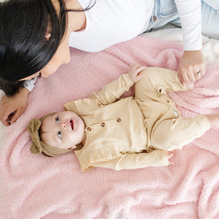 Saranoni Bamboni® Receiving Blanket - Light Pink
Baby lying on a pink blanket with a person partially visible above