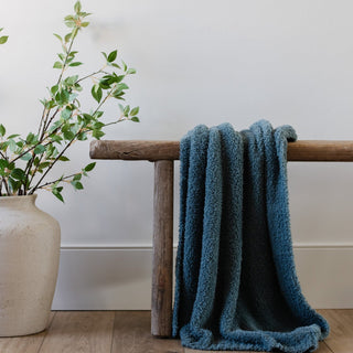 Saranoni Bamboni® Receiving Blanket - Spruce
Blue towel draped over a wooden bench next to a vase with greenery on a light wood floor.