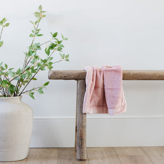 Saranoni Lush Mini Blanket - Ballet Slipper
Pink towel draped over a wooden bench next to a potted plant on a light wood floor.