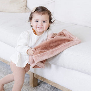 Saranoni Lush Mini Blanket - Rosy
Child holding a pink blanket on a white couch
