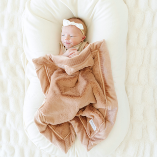 Saranoni Lush Mini Blanket - Rosy
Newborn baby wrapped in a pink blanket on a white cushion
