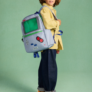 State Bags Kane Backpack - Vidoegame Child wearing a backpack designed like a vintage video game console against a green background