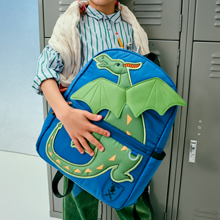 State Bags Kane Backpack - Dragon
Person holding a blue backpack with a dragon design in front of lockers.