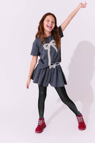 Lola and The Boys Sparkle Bow Charm Skirt Set Young girl in a gray dress with a bow, black tights, and red shoes on a white background