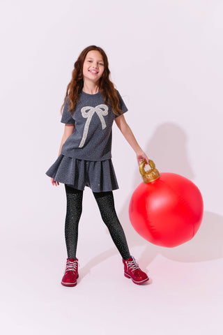 Lola and The Boys Sparkle Bow Charm Skirt Set Girl holding a large red Christmas ornament against a white background