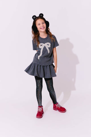 Lola and The Boys Sparkle Bow Charm Skirt Set Young girl wearing a gray outfit with a bow design, black tights, and red shoes on a white background