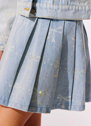 Lola and The Boys Sparkle Bows Denim Pleated Skirt
Close-up of a light blue denim pleated mini skirt with rhinestone bow details and a matching belt, shown on a model.