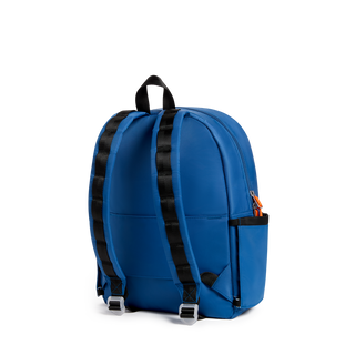 State Bags Kane Backpack - Dragon 
A royal blue backpack with black padded shoulder straps and silver buckle adjusters, shown from a three-quarters rear view on a white background.