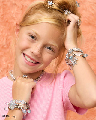 Super Smalls Disney Frozen Snowflake Hair Clips
Young girl wearing multiple bracelets and a headband with decorative elements on a peach background.