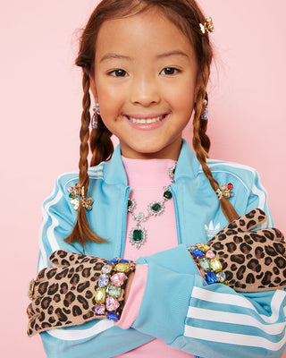 Super Smalls Jungle Jeweled Gloves
Child wearing a blue jacket with colorful accents and leopard print gloves on a pink background
