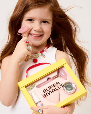 Super Smalls Mom's Beauty Starter Kit
Young girl holding a 'Super Smalls' toy set with a yellow box.