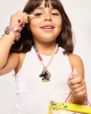 Super Smalls Unicorn Makeup Play Kit
Young girl applying makeup with a brush and pink lip gloss, wearing a white sleeveless top and colorful jewelry.