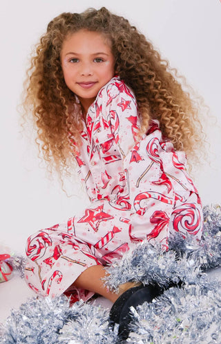 Lola and The Boys Sweet Winter Silky Set
Child wearing a red and white patterned outfit sitting on a white background with tinsel.