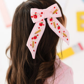Sweet Wink Apple Gemstone Bow Clip
Pink bow hair clip with decorative elements on a blurred background