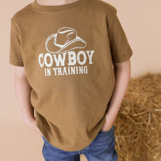 Sweet Wink Cowboy In Training Western Short Sleeve T-Shirt
Child wearing a brown t-shirt with 'Cowboy in Training' text and a cowboy hat graphic.