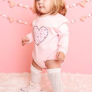 Sweet Wink Dainty Rose Pearl Heart Patch Long Sleeve Romper - Ballet
Child wearing a pink sweatshirt with a heart design on a pink background